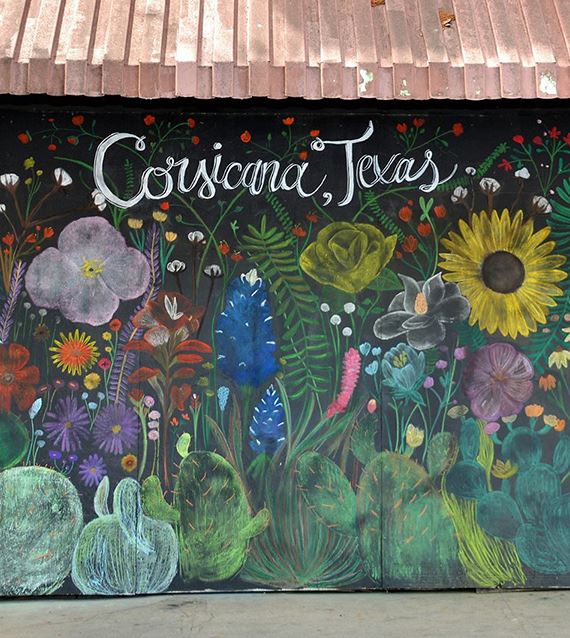 a side of a wall painted with flowers and the words with Corsicana Texas